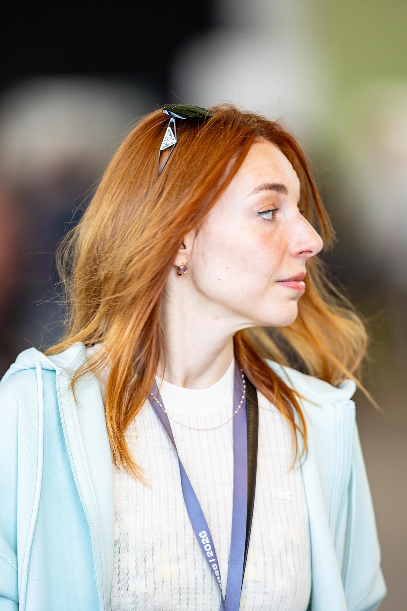 Woman in a light blue blazer looking off camera at an event