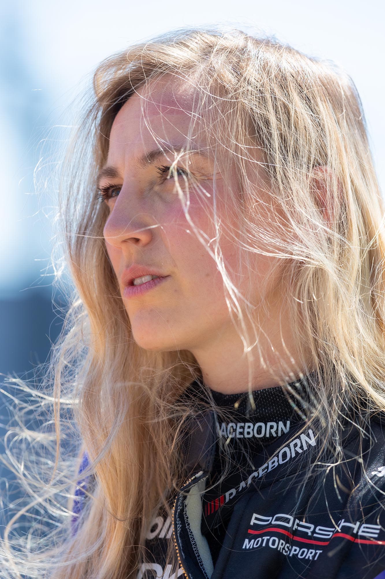Portrait of a driver in the paddock, hair caught by the wind