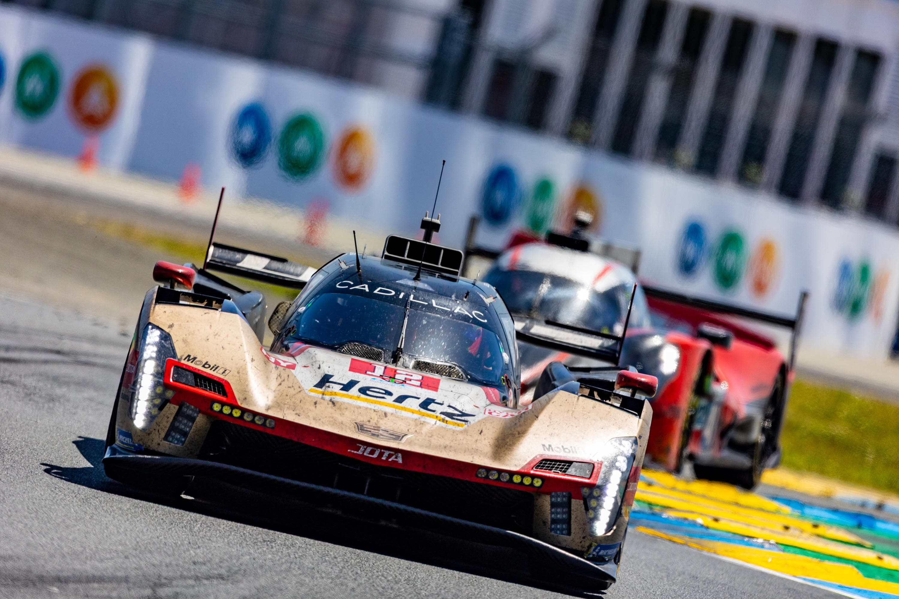 Le Mans hypercar racing past the Motul hoardings